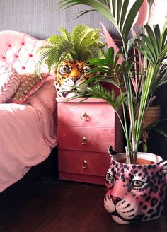 a leopard head planter next to a pink bed