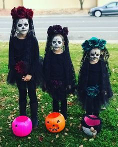 three children in halloween costumes standing next to each other