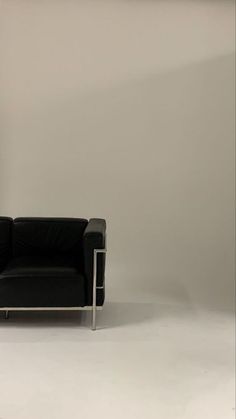 a black leather chair sitting in front of a white wall