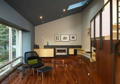 a living room with hard wood floors and large windows