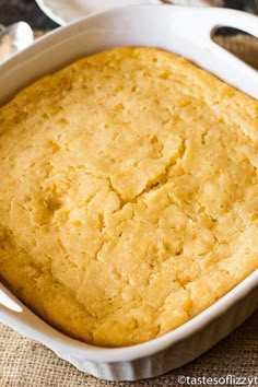 a casserole dish with cornbread in it on top of a cloth covered table