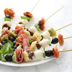 a white plate topped with skewers filled with meat and veggies