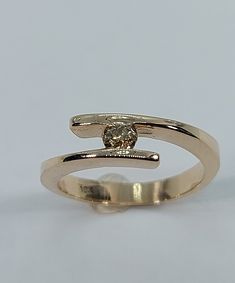 This handmade, beautiful  ring has been expertly crafted in warm 10k yellow gold and authentic Champagne diamonds. This gorgeous ring will make a great any occasion/Christmas gift. All of my jewelry is handmade from scratch, one item at a time as I like to make sure I am producing a high quality piece. Upon request a personalized message can be added to the inside of the ring. A tracking shipping number will be provided to you once the ring has been shipped. Diamonds measurements: 1 Diamonds: 3. Elegant Gold Sapphire Ring With Tension Setting, Gold Solitaire Bypass Ring Gift, Gold Solitaire Bypass Ring Fine Jewelry, Gold Solitaire Bypass Ring As Gift, Gold Solitaire Bypass Ring In Fine Jewelry Style, Gold Bypass Ring With Diamond Cut For Anniversary, Gold Solitaire Ring With Open Band, Gold Diamond Cut Bypass Ring For Anniversary, Gold Bypass Ring With Polished Finish For Promise