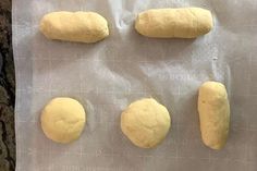 four uncooked doughs on a piece of parchment paper