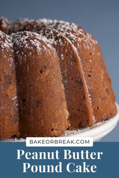 a bundt cake with powdered sugar on top sits on a white pedestal and is ready to be eaten