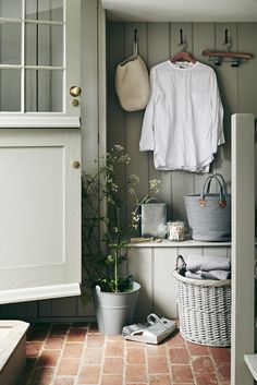 a white shirt hanging on the wall next to a potted plant in a room