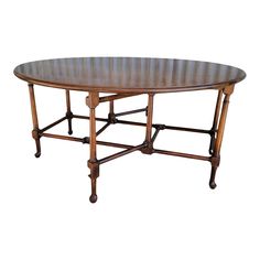 an oval wooden table with four legs and a center piece at the top, on a white background