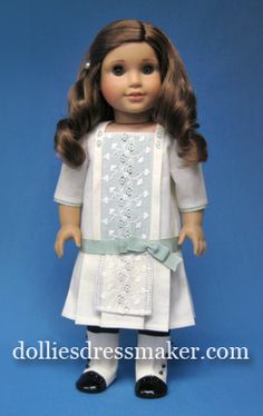 the doll is wearing a white dress and black shoes