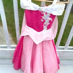 a pink and white dress hanging on a rail