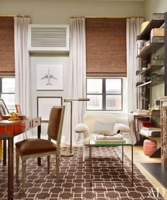 a living room filled with lots of furniture and windows covered in shades of brown blinds