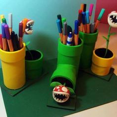 two green cups with toothbrushes and pencils in them