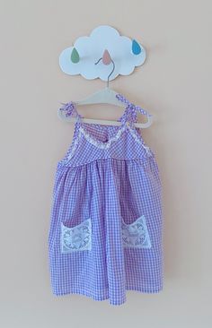 A perfect outfit for summer holidays, days at the beach, family picnics as well as everyday comfortable chicness, this sweet lilac purple cotton sundress is a very girly piece in a charming classic gingham pattern.  It features an A line silhouette, tie straps and the sweetest white lace pockets, which elevate an otherwise very simple sundress style.  A breezy and stylish summer piece for your little fashionista's wardrobe!  Length: 20 inches Underarm to underarm flat: 13 inches Summer Cotton Sundress For Picnic, Summer Style Cotton Sundress For Picnic, Summer Gingham Sundress For Vacation, Gingham Dress For Summer Picnics, Purple Ruffled Sundress For Summer, Lavender Beach Dress For Summer, Gingham Dress For Summer Picnic, Gingham Beach Dresses For Summer, Gingham Dresses For Summer Picnics