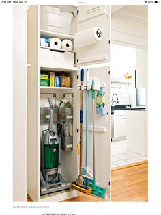 an open refrigerator with cleaning supplies and tools in it's door, next to a hardwood floor