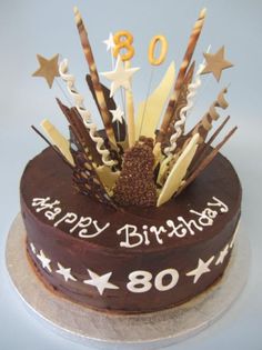 a chocolate birthday cake with white stars and numbers on the top is decorated with candles