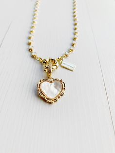 "Made of raw brass and 16Kt gold plated fot the necklace and 18k the pendant. Brass micro pave cubic zirconia heart pendant, with Natural Shell, Real 18K Gold Plated Size: about 32mm long, hole: 6.5x9mm, heart: 19x20x3mm. Can be opened to attach it to any link or closure. Opal enamel connectors necklace made of 16k gold plated brass. Each connector measures 7x5mm (0.27\"x0.2\") and total necklace length is 38cm (15\") or 42cm (16 1/2\") It has a big spring clasp to add multiple charms! includes a brand logo laser engraved tag in the closure You can choose only the pendant or pendant plus matching necklace. Comes with a brand box perfect to make a gift and to keep it save." Gold Dainty Heart Necklace With Pearl Charm, Delicate Heart Necklace With Pearl Charm, Dainty Heart-shaped Brass Necklaces, Delicate 14k Gold Filled Heart Charm Necklace, Brass Heart Pendant Necklace With Lobster Clasp, Delicate Gold Charm Necklace With Lobster Clasp, Dainty Brass Charm Necklace With Lobster Clasp, Delicate Brass Charm Necklace With Adjustable Chain, Dainty Necklace With Vintage Heart Pendant