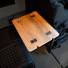 two wooden boards sitting on top of a black leather seat in the back of a vehicle