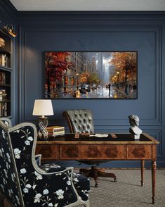 an office with blue walls and a painting on the wall