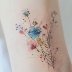 a close up of a tattoo with flowers on it