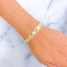 This bangle showcases an exclusive and sleek design, crafted from 22k gold, highlighted by the striking contrast between yellow and white gold finishes. It features a sophisticated embellishment of cubic zirconia stones, adding a touch of brilliance and elegance. Weighing 20.5 grams, this piece combines luxury with a modern aesthetic. The bangle is designed with a size of 2.7 and a bangle opening of 2.45 inches, ensuring a comfortable fit for those with a slightly larger wrist size. Ideal for individuals who seek a blend of contemporary design and timeless materials, this bangle is a standout accessory that complements both casual and formal attire. PRODUCT DETAILS Gold Purity(karat): 22k Item Weight(grams): 20.5 Item Finish: Yellow + White Gold Stone: Cubic Zirconia Size: 2.7 Bangle Openi Luxury Gold Cuff Bracelet With Single Cut Diamonds, Modern Gold Cubic Zirconia Cuff Bracelet, Modern Gold Cuff Bracelet With Cubic Zirconia, Luxury Gold Bangle With Single Cut Diamonds, Modern Gold Bangle With Single Cut Diamonds, Designer Gold Diamond Jubilee Bracelet, Gold Bangle Tennis Bracelet For Everyday Luxury, Luxury Gold Cuff Bracelet With Diamond Accents, Designer Gold Diamond Bangle Bracelet