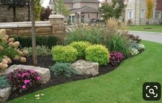 a garden with rocks and flowers in the grass