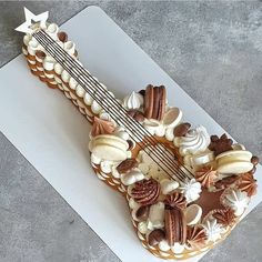 a guitar shaped cake sitting on top of a white cutting board next to a knife