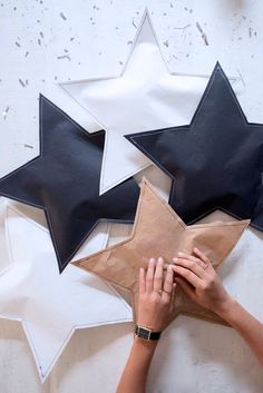 two people reaching up to put stars on the wall above their heads, with one person holding a brown paper bag in front of them