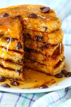 chocolate chip pancakes stacked on top of each other with syrup drizzled over them