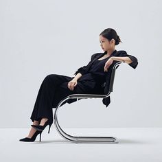 a woman sitting in a chair with her legs crossed