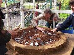 three people standing around a cake made out of wine corks