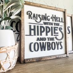 a wooden sign that says raising hell with the hippies and the cowboys