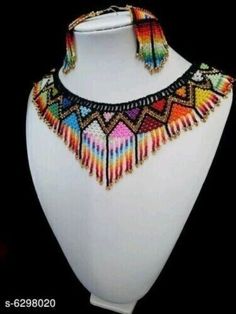 a white mannequin with multicolored necklace and earrings on top of it