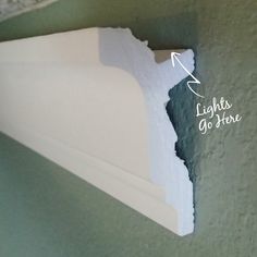 the corner of a wall that has been painted with white paint and labeled lights of here