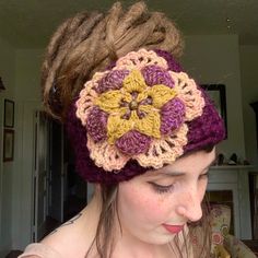 a woman with dreadlocks wearing a crochet flower headband