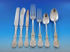 an assortment of silverware including forks, knives and spoons on a blue background