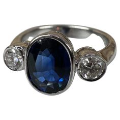 Three stone diamond ring made with sapphire and two diamonds in 18KT white gold. GOLD: 18KT gold NATURAL DIAMOND(S) Clarity/Color: VS/G Carat:0.32ct NATURAL SAPPHIRE(S) Clarity/Color: Slightly Included/Blue Carat:2.20ct Grams:6.54 size: 7 Item#: 200-00004 MTTT WHAT YOU GET AT STAMPAR JEWELERS: Stampar Jewelers, located in the heart of Jupiter, Florida, is a custom jewelry store and studio dedicated to providing 100% satisfaction to each client. Our personal attention to detail, passion, affordab Platinum Sapphire Ring In White Gold With Diamond Accents, White Gold Sapphire Gemstone Ring, Formal Three Stone Sapphire Ring, Fine Jewelry Sapphire Ring In White Gold, Fine Jewelry White Gold Sapphire Ring, Platinum White Gold Sapphire Ring With Diamond Accents, Three Stone Sapphire Ring With Diamonds, Formal Sapphire Three Stone Rings, Classic Ring With Polished Lab-created Sapphire