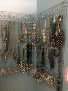 a closet filled with lots of necklaces and bracelets hanging on the wall next to a toilet