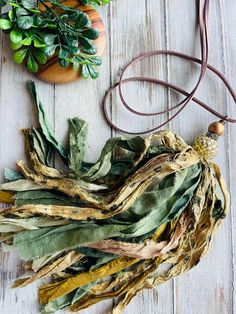 dried plants are on the table next to a necklace and other items that have been placed around them