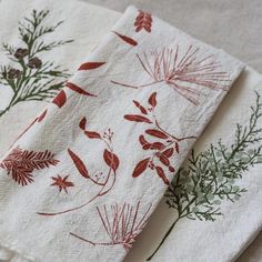 three napkins with red and green designs on them are sitting next to each other