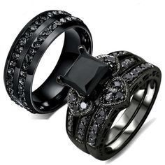 two black wedding rings with white diamonds on each one and an engagement ring in the middle