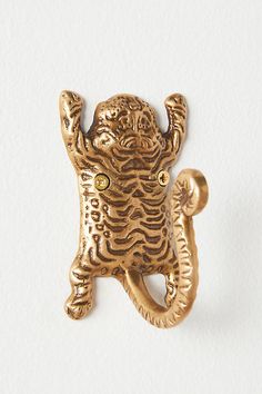 a gold colored brooch with an elephant head on it's back and eyes open