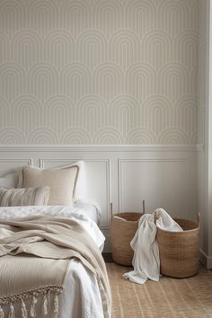 a white bed sitting next to a basket on top of a wooden floor