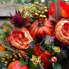 an arrangement of flowers and fruits on a bench