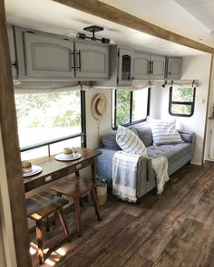 a living area with couch, table and windows