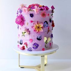 a pink cake decorated with flowers on a white plate