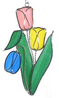 three colorful flowers hanging from a metal chain