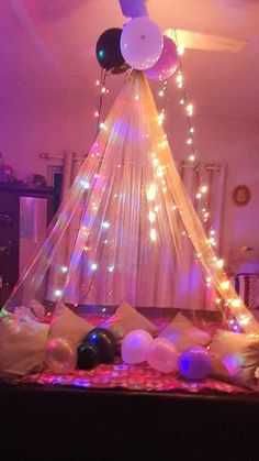 a bed with balloons and lights on it