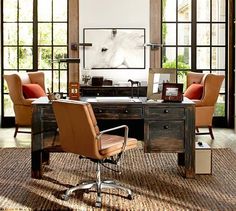 an office with two chairs and a desk in front of large open windows that look out onto the yard