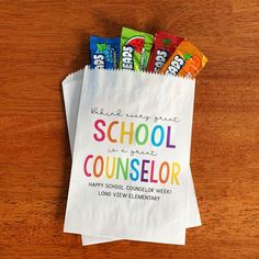 some candy bars are sitting on top of a paper bag that says school is a great counselor