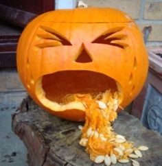 a carved pumpkin with its mouth open and sunflower seeds coming out of it's side