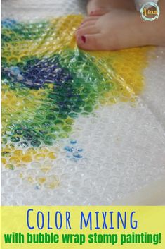 a child's feet on top of a table covered in bubbles and colored mixing